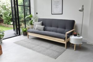 Living room with sofa bed and pillows, and sidetable
