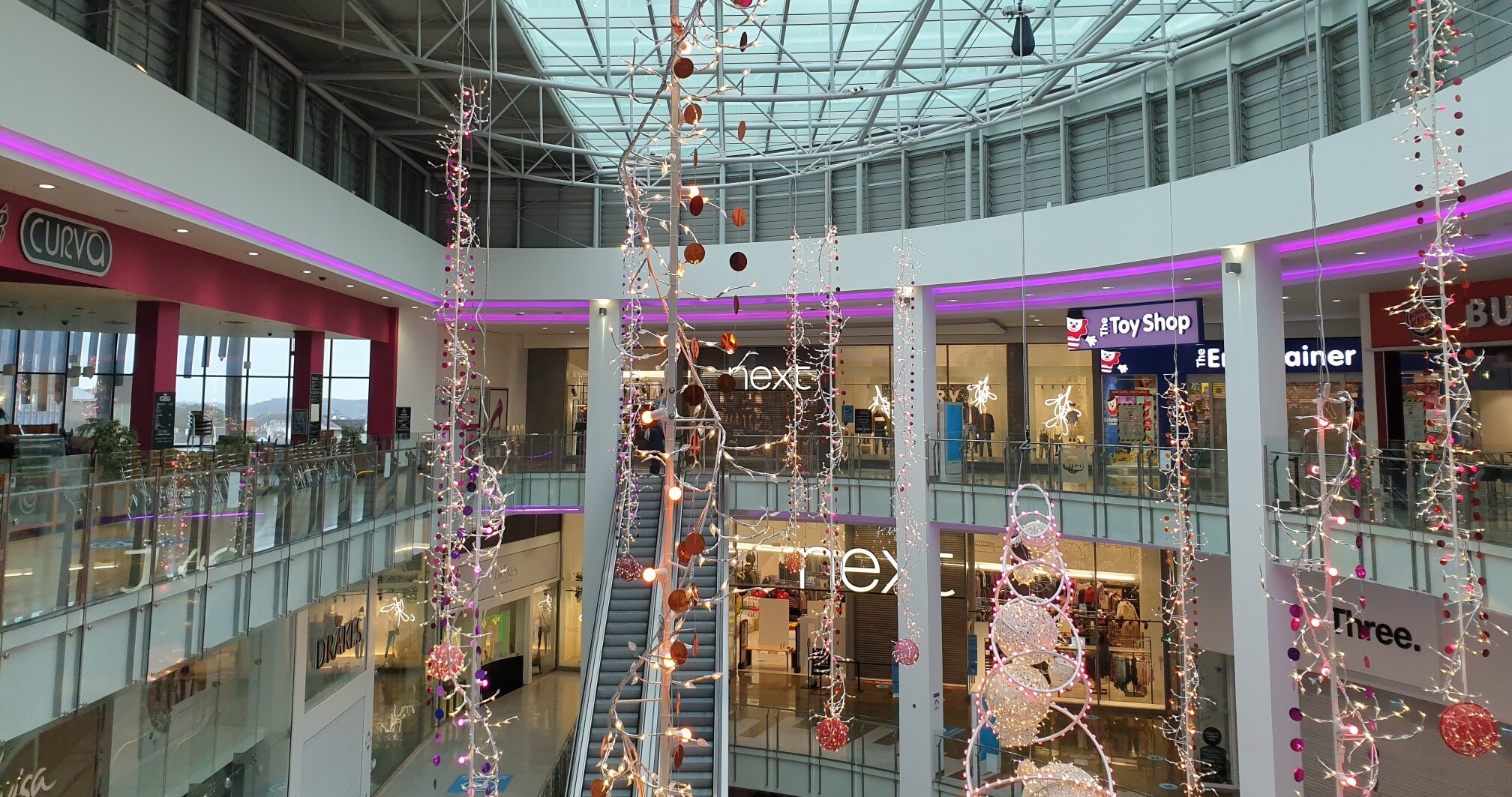 Christmas decorations hanging off ceiling in shopping mall